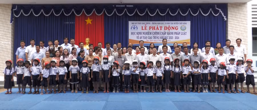 Trao mũ bảo hiểm cho HS và phát động HS chấp hành pháp luật về an toàn giao thông trên địa bàn.