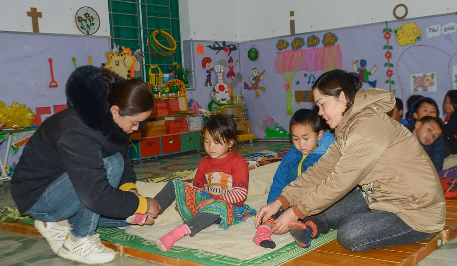 Giáo viên điểm Nậm Ty 2, Trường Mầm non Hua Thanh hướng dẫn học sinh đi tất giữ ấm.