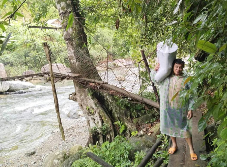 Thầy Hồ Văn Ngọc cõng lương thực dự trữ đủ cho một tuần để nấu ăn bữa trưa cho học sinh điểm trường Ông Thái, Trường PTDTBT Tiểu học Trà Dơn (Nam Trà My, Quảng Nam). Ảnh: NTCC