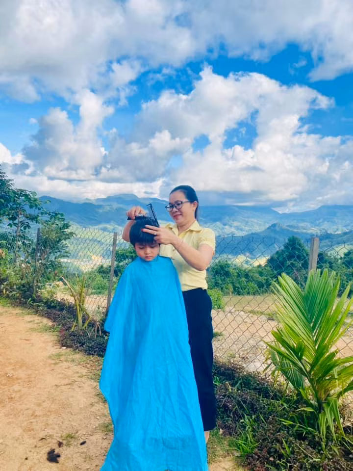 Cô giáo Nguyễn Thị Thu Ba cắt tóc cho học sinh.