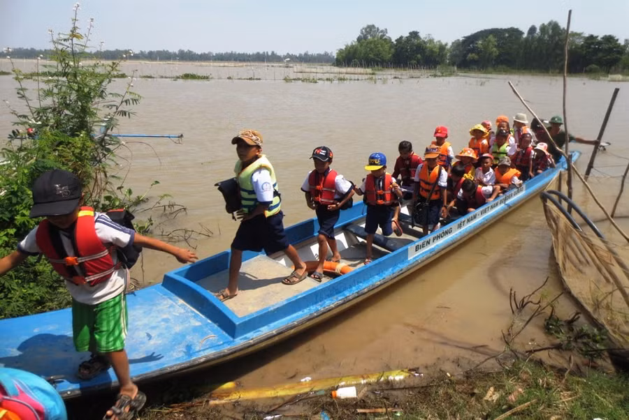 Chiến sĩ Đồn biên phòng ở huyện Tân Hồng (Đồng Tháp) đưa đón HS vùng lũ đến trường.