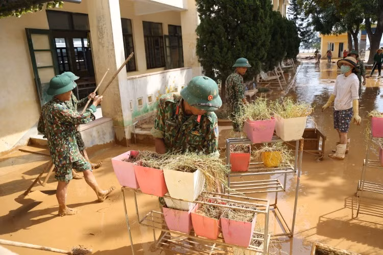 Lực lượng chức năng hỗ trợ thầy cô Trường Tiểu học Hàm Ninh (huyện Quảng Ninh, tỉnh Quảng Bình). Ảnh: Thế Đại