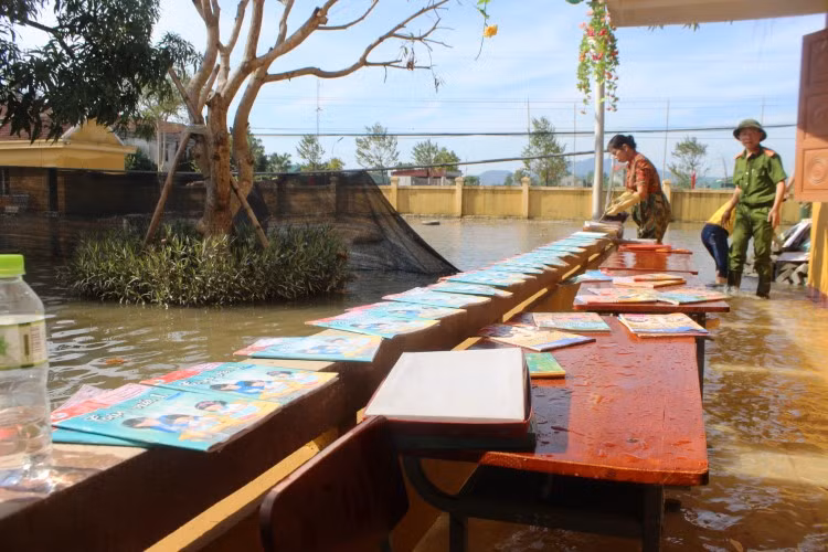 Giáo viên Trường Tiểu học Thạch Tân huyện Thạch Hà (Hà Tĩnh) phơi sách vở sau bão lũ. Ảnh: Trương Hoa