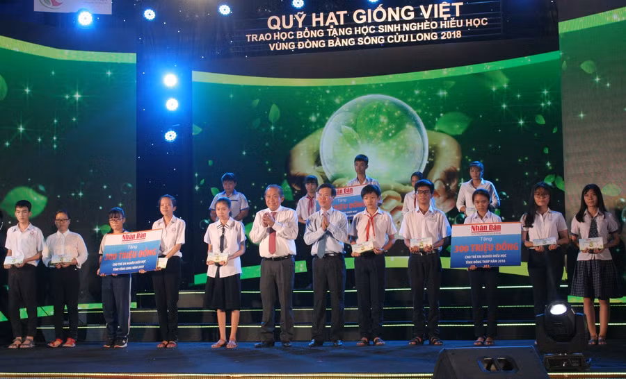 Đồng chí Trương Hoà Bình - Phó Thủ tướng Thường trực Chính phủ và đồng chí Võ Văn Thưởng - Trưởng Ban Tuyên giáo Trung ương trao học bổng cho các em HS