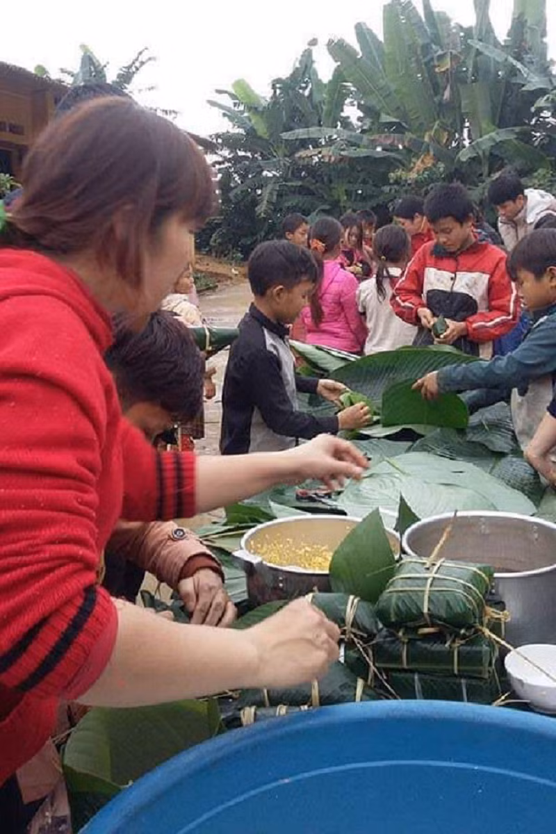 Giáo viên hướng dẫn học sinh gói bánh chưng. Ảnh: NTCC
