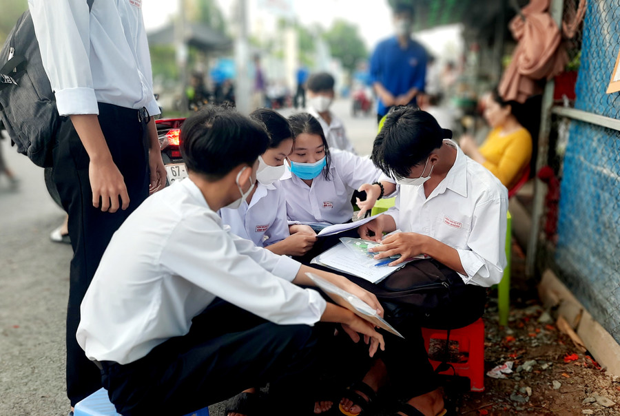 Thí sinh trao đổi bài vở trước giờ thi.