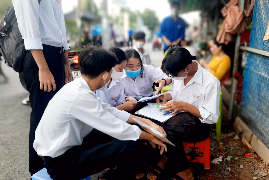 Thí sinh trao đổi bài vở trước giờ thi.