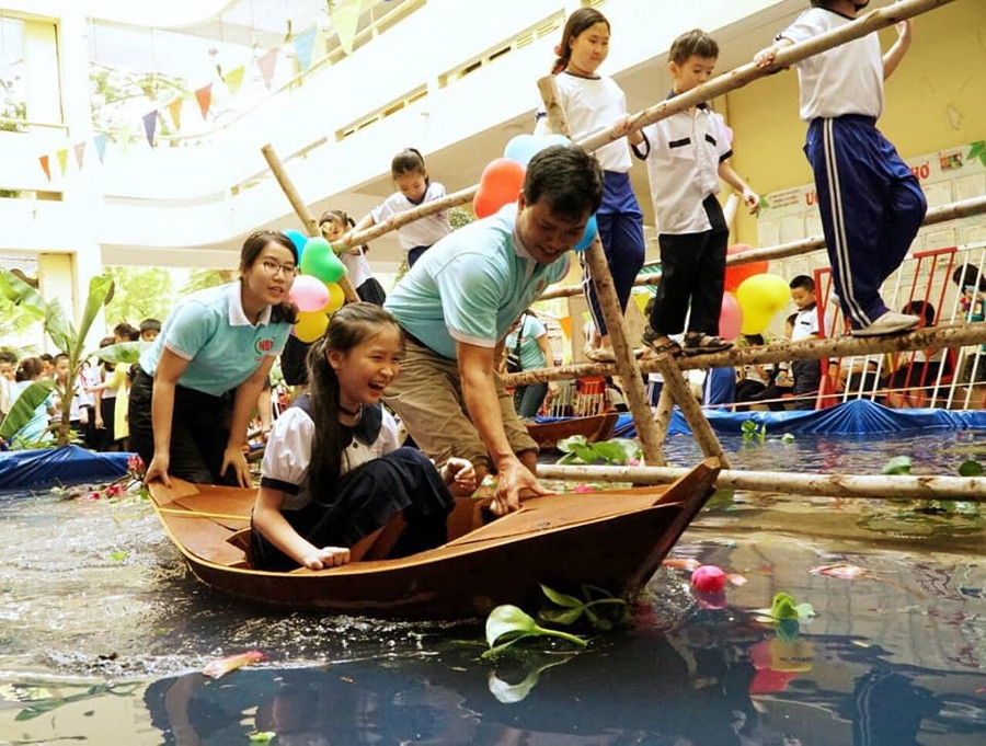 Học sinh Trường Tiểu học Nguyễn Bỉnh Khiêm thích thú với trải nghiệm đi cầu khỉ, ngồi thuyền tại ngày hội Xuân ở trường