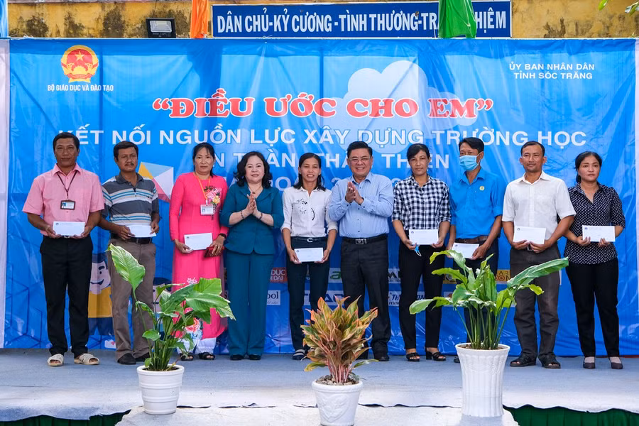 Thứ trưởng Ngô Thị Minh; ông Châu Tuấn Hồng, GĐ Sở GD&amp;ĐT Sóc Trăng trao quà cho các giáo viên.