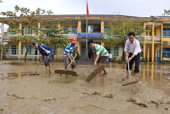 Thầy cô hối hả dọn trường sau bão lũ. Ảnh: vnexpress.net