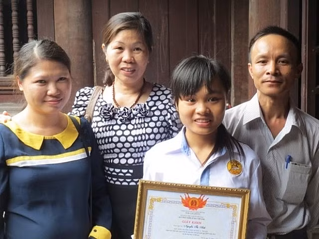 Cô giáo Lê Thị Thanh Lâm (ngoài cùng bên trái) cùng học sinh Nguyễn Thị Anh đến Văn Miếu nhận phần thưởng cho học sinh đạt giải Nhất quốc gia môn Lịch sử năm 2013. Ảnh: Nguyễn Hải - báo Pháp luật và xã hội