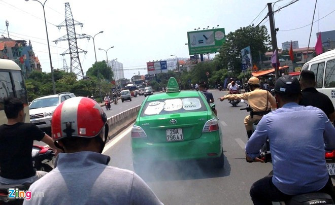 Tài xế hung hãn tông cảnh sát giao thông khai gì khi bị bắt? ảnh 2 Nhiều người dân truy đuổi chiếc taxi bỏ chạy trưa 25/8. Ảnh: Cắt từ clip.