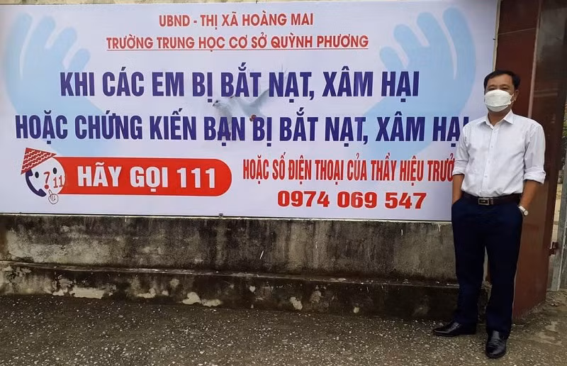 Thầy Hồ Tuấn Anh - Hiệu trưởng Trường THCS Quỳnh Phương (thị xã Hoàng Mai, Nghệ An) trước tấm panô ấn tượng.