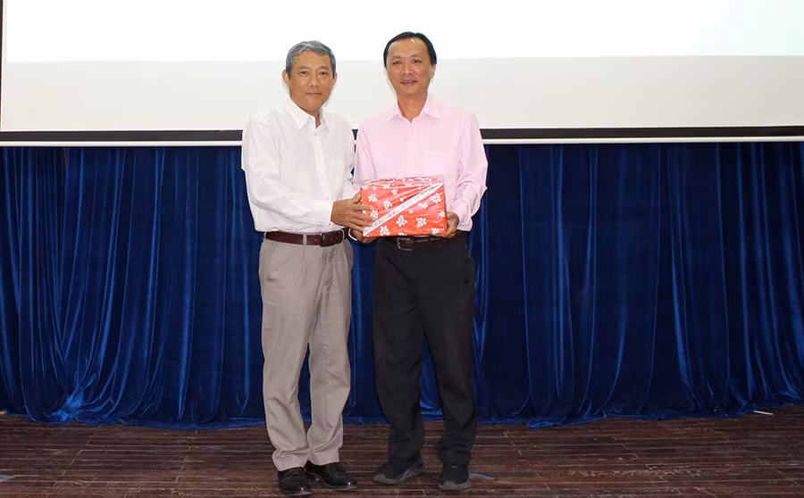 PGS.TS Hồ Thanh Bình - Phó Hiệu trưởng Trường ĐH An Giang trao quà lưu niệm của Hội Khuyến học tỉnh An Giang cho gia đình liệt sĩ Huỳnh Thiện Nghệ.