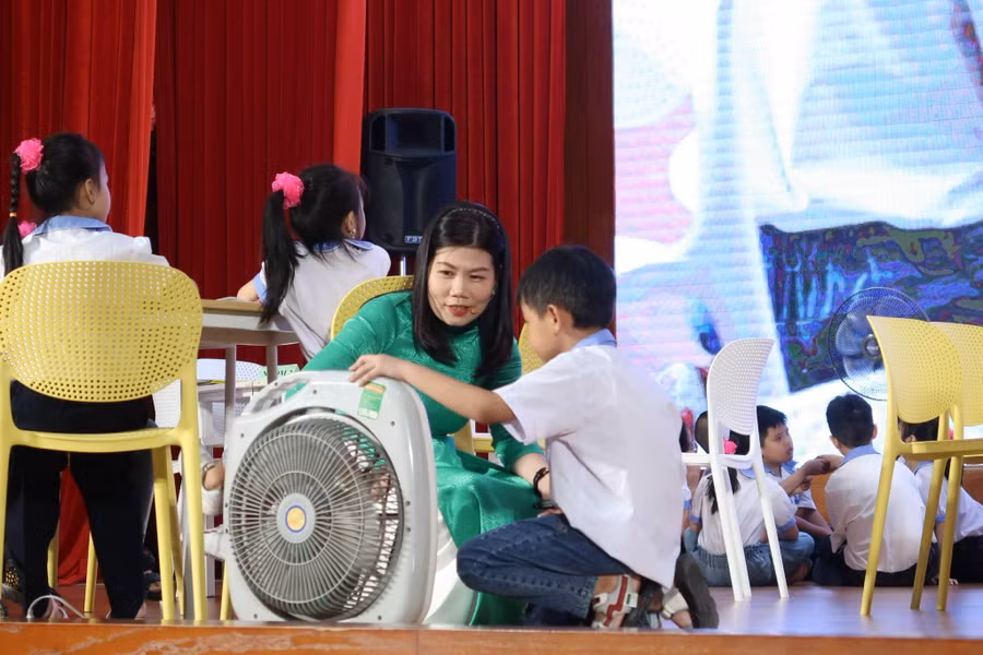 Cô Mai hướng dẫn học trò các bước sử dụng quạt điện an toàn.