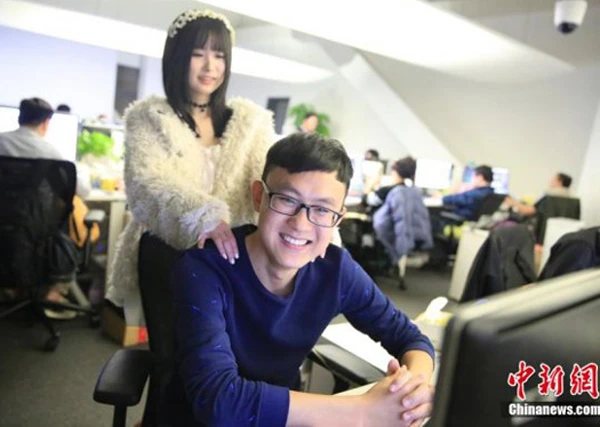 Một chàng lập trình viên cười tươi khi được cô gái trẻ xoa bóp vai. Ảnh: China News