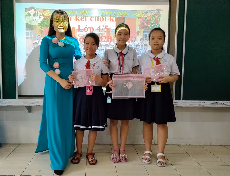 Em Bùi Khánh Linh (thứ 2 từ phải sang) và cô chủ nhiệm trong buổi sơ kết cuối học kỳ II, lớp 4. Ảnh: NVCC