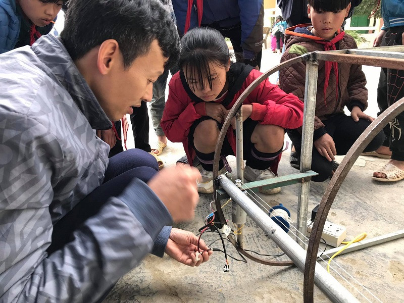 Thầy Lê Thắng Trung hướng dẫn HS Giàng Thị Dinh lắp ráp “Giàn phơi thông minh cho học sinh bán trú”. Ảnh: NTCC Thầy Lê Thắng Trung hướng dẫn HS Giàng Thị Dinh lắp ráp “Giàn phơi thông minh cho học sinh bán trú”. Ảnh: NTCC