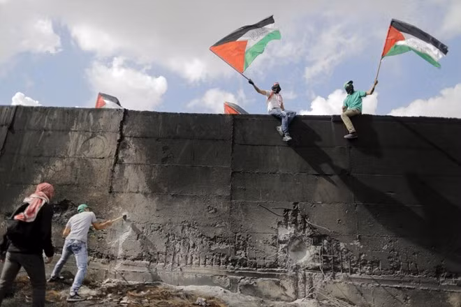 Người biểu tình Palestine dùng búa đập bức tường chắn do Israel xây dựng ở thị trấn bờ Tây Abu Dis hôm 28/10 vừa qua. Sóng Tiền Đường quật ngã du khách lọt top ảnh tuần