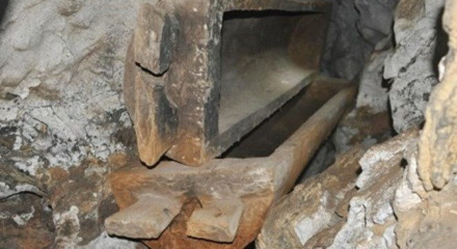 Chiếc quan tài bằng thân gỗ nguyên khối được gác trên một vách đá. Mô tả ảnh.