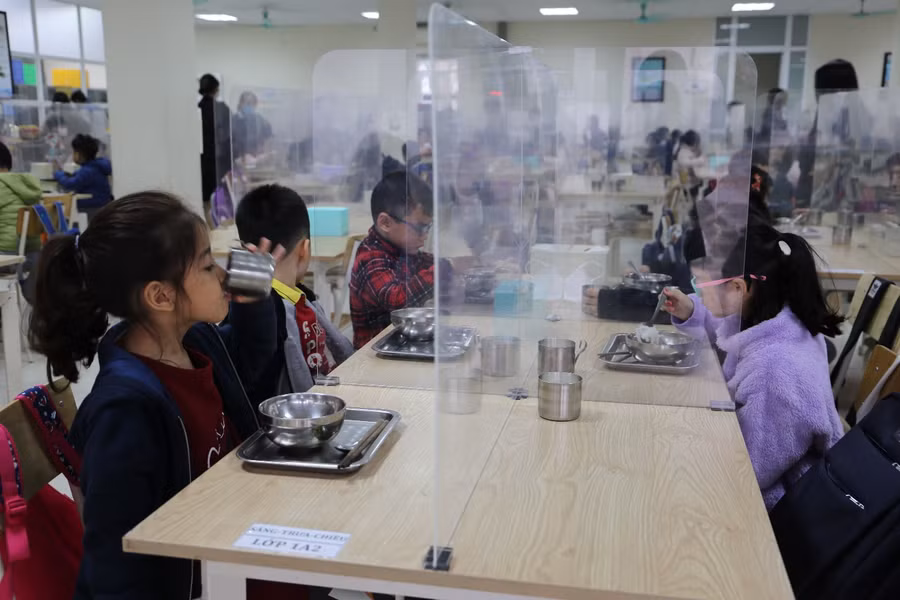 Học sinh ăn sáng tại bàn có vách ngăn