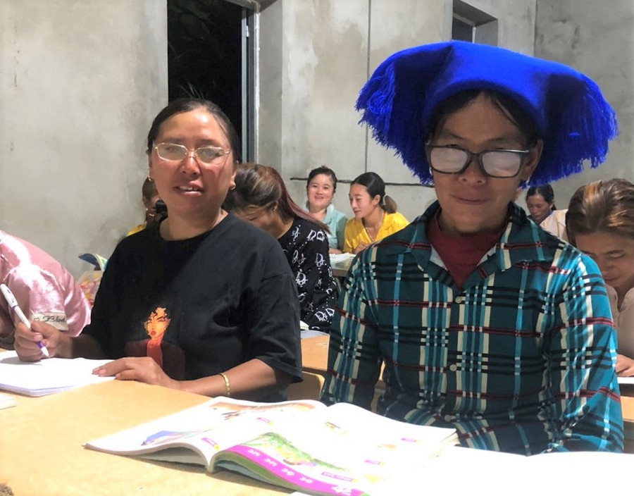 Bà Sần Ga Giê (bên phải) học viên cao tuổi nhất tại lớp xóa mù chữ bản Dền Thàng.