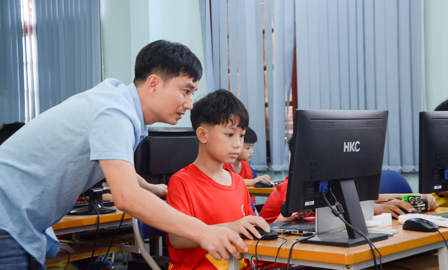 Lò Đức Anh say sưa thực hiện khớp nối từng câu lệnh trên máy tính để điều khiển robot theo ý.