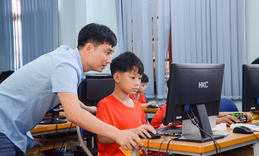 Lò Đức Anh say sưa thực hiện khớp nối từng câu lệnh trên máy tính để điều khiển robot theo ý.