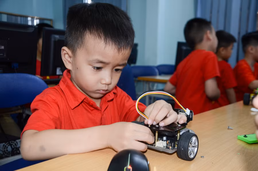 Cậu bé Trần Anh Khôi say sưa tháo lắp robot.