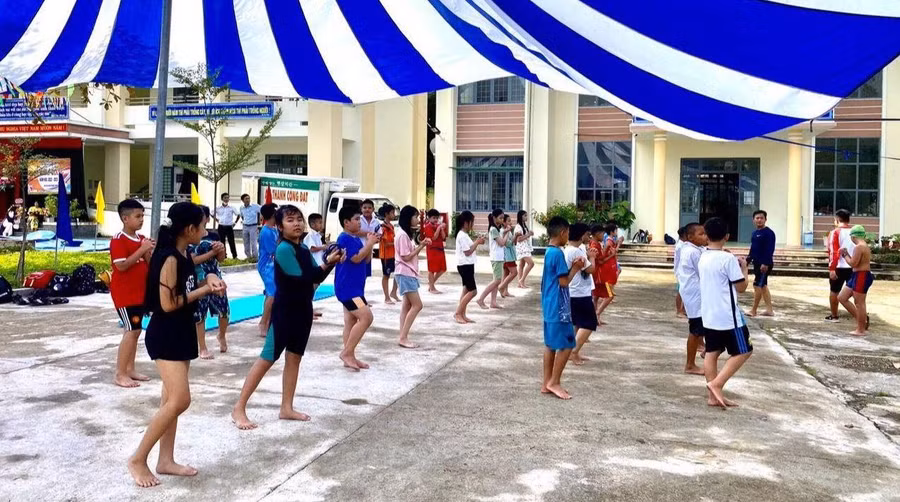 Học sinh khởi động trước khi xuống hồ học bơi.