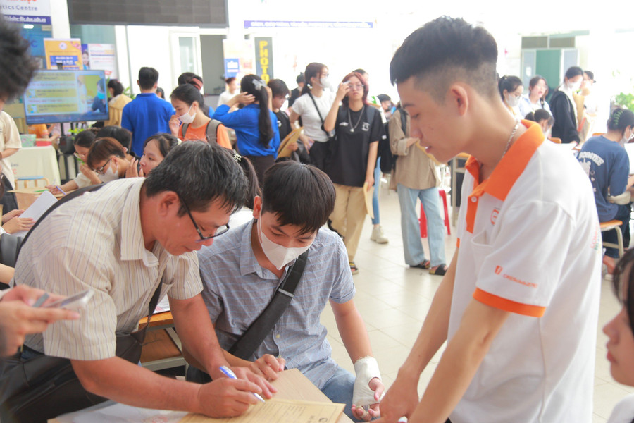 Lực lượng sinh viên tình nguyện Trường ĐH Kinh tế, ĐH Đà Nẵng tham gia hỗ trợ, hướng dẫn phụ huynh và tân sinh viên hoàn tất hồ sơ nhập học.