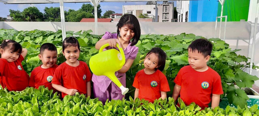 Cô Nguyễn Thùy Dung cùng trẻ chăm sóc vườn rau xanh.