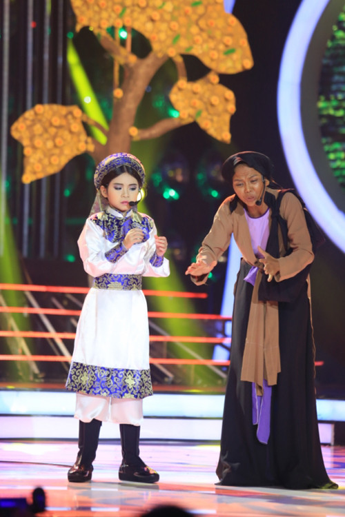 Vừa đoạt giải nhất ở tuần 7, Trang Thư có thêm tinh thần để diễn lại trích đoạn "Thanh gươm và nữ tướng" của nghệ sĩ Trinh Trinh. Mặc dù chưa bao giờ hát cải lương nhưng cô bé đã tập luyện kỹ lưỡng để hoàn thành tiết mục. my-linh-phai-long-be-bao-ngoc-11