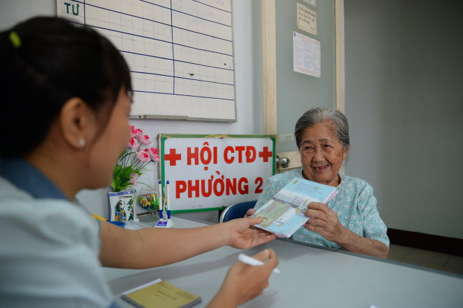Một cụ bà ở P.2, Q.Phú Nhuận (TP.HCM) đến UBND P.2 đăng ký mua BHYT - Ảnh: Hữu Khoa