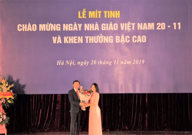 GS Nguyễn Văn Minh nhận bó hoa tươi thắm từ học trò tại lễ kỷ niệm 37 năm ngày Nhà giáo Việt Nam.