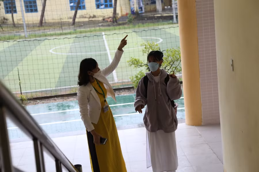 Cô giáo Trường THPT Tôn Thất Tùng hướng dẫn cho HS lớp 10 vào vị trí lớp học.