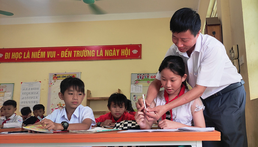 Thầy Lê Xuân Viên đang ân cần dạy cách cầm bút cho học sinh của mình. Thầy Lê Xuân Viên đang ân cần dạy cách cầm bút cho học sinh của mình.