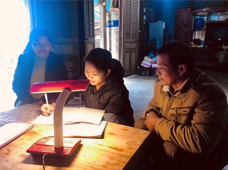 Vợ chồng ông Mà A Khai hướng dẫn con học bài.