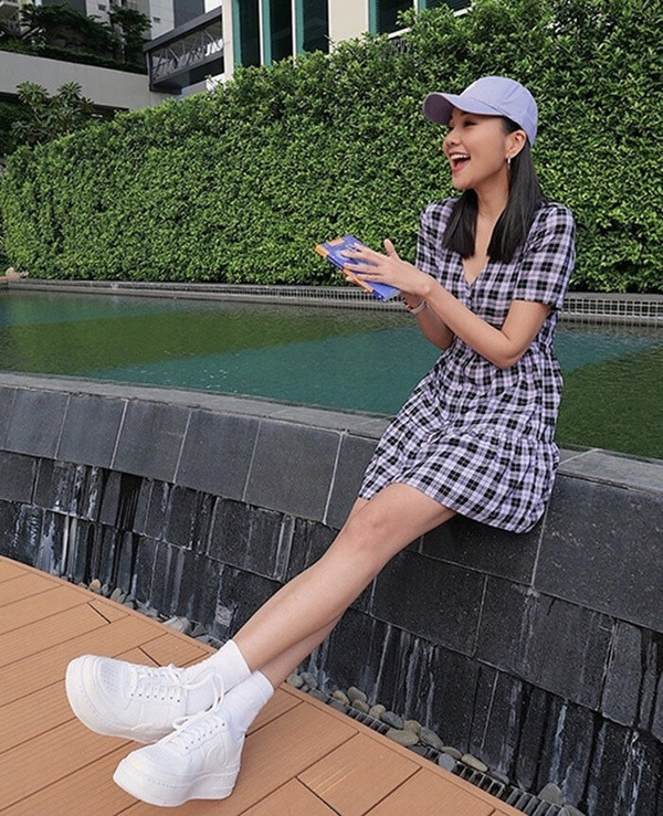 Thanh Hằng &quot;hack tuổi&quot; với mẫu váy caro ngắn trẻ trung năng động. Giày sneakers màu trắng, mũ lưỡi trai là những phụ kiện lý tưởng giúp hoàn thiện vẻ ngoài tươi trẻ cho cô nàng.