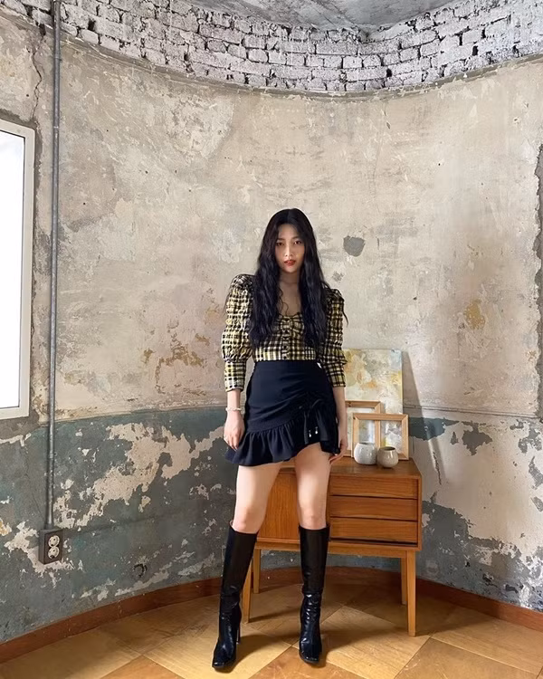 Joy cũng lăng xê xu hướng họa tiết kẻ caro bằng cách chọn cho mình một mẫu áo tay bồng cổ vuông. Mix item này cùng chân váy ngắn, nữ idol khéo hoàn thiện set đồ bằng đôi boots đùi thời thượng.