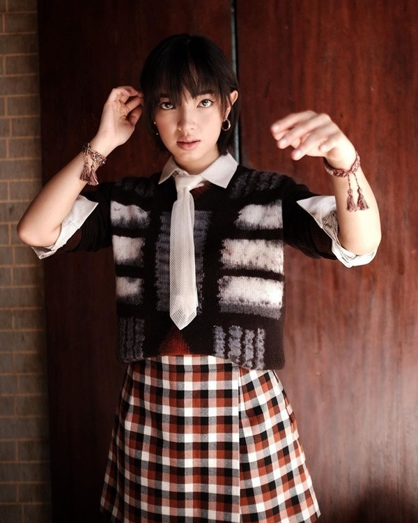 Châu Bùi mang đến set đồ đầy thú vị khi mix layer sơ mi trắng cùng áo len và chân váy kẻ caro.