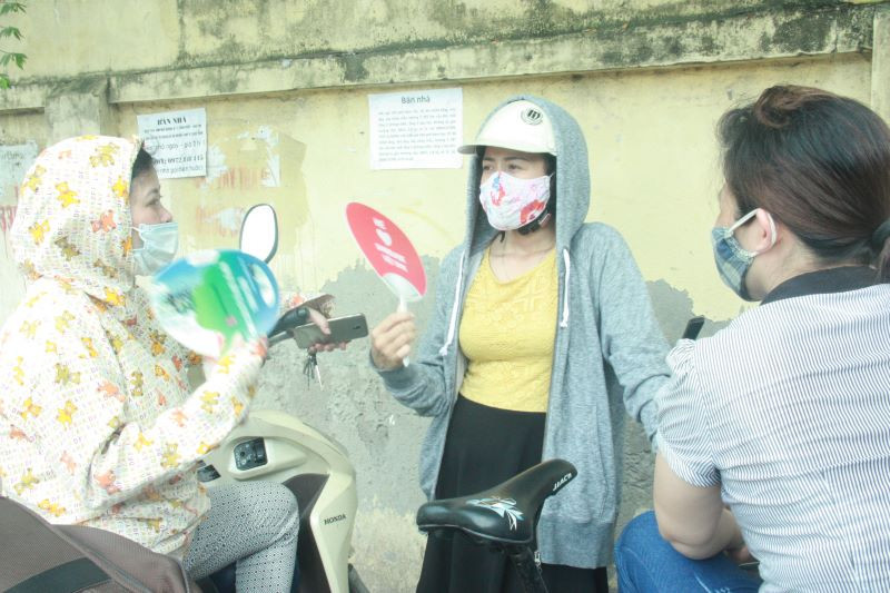 Chị Hồ Thu Hà, chị Bùi Thị Mùi (trái và phải ảnh) chờ con tại điểm thi Trường THPT Hoàng Văn Thụ (Hà Nội)