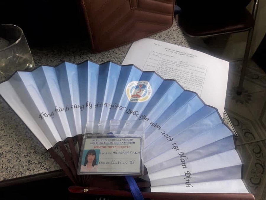 Chiếc quạt in dòng chữ "Đồng hành cùng kỳ thi THPT quốc gia năm 2019 tại Nam Định" giúp các cán bộ coi thi giảm bớt cái nóng giữa hè