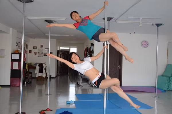 Bà Jiang thể hiện một đông tác múa cột cùng con gái.