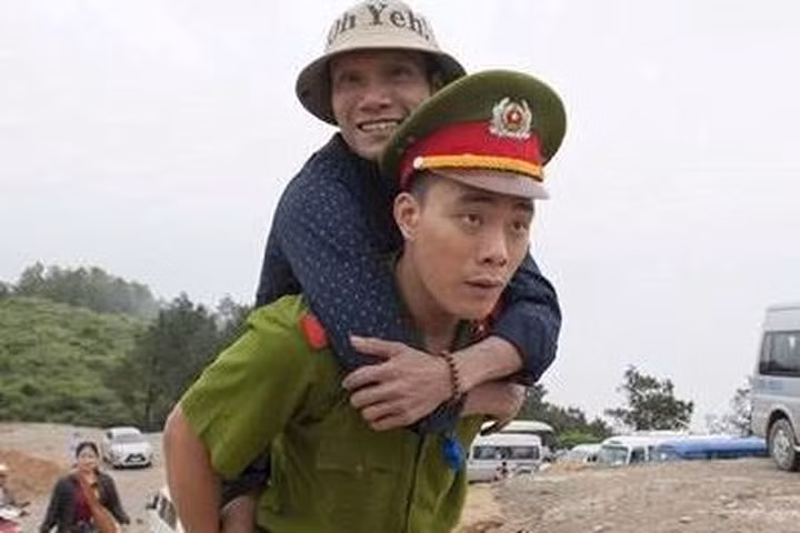 Nam cảnh sát cõng người đàn ông cụt 2 chân lên núi