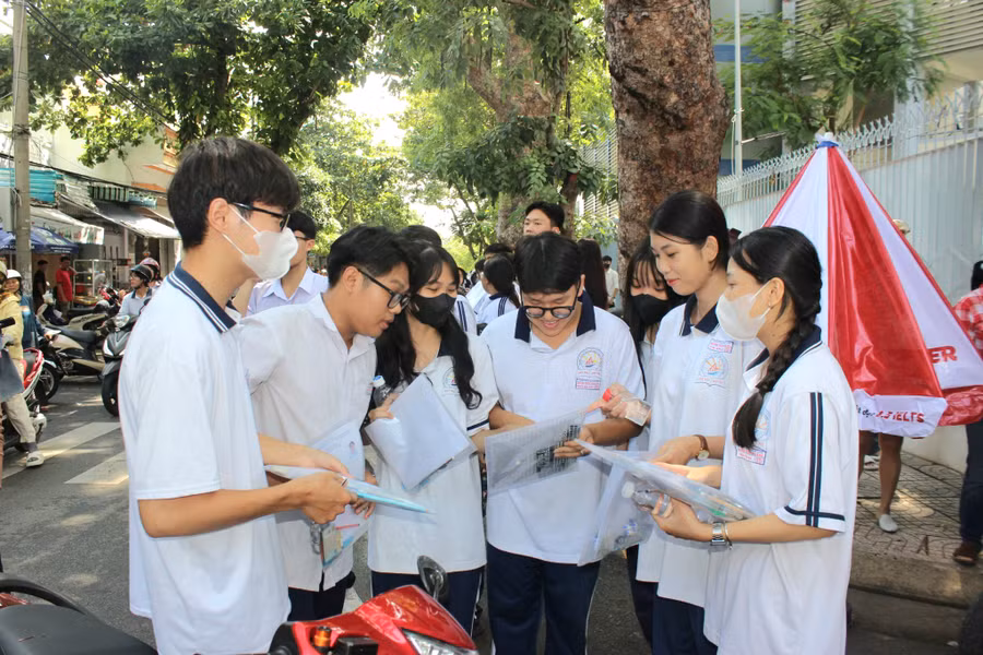 Một số thí sinh đến sớm tranh thủ trao đổi về đề thi môn Ngữ văn và phương pháp giải đề Toán nhanh tại điểm thi Trường THPT Đinh Tiên Hoàng.