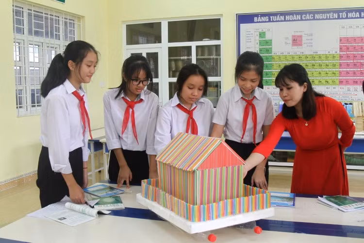 Cô Nguyễn Thị Chung nghe HS lớp 8A thuyết trình về sản phẩm nhà nổi chống lũ.