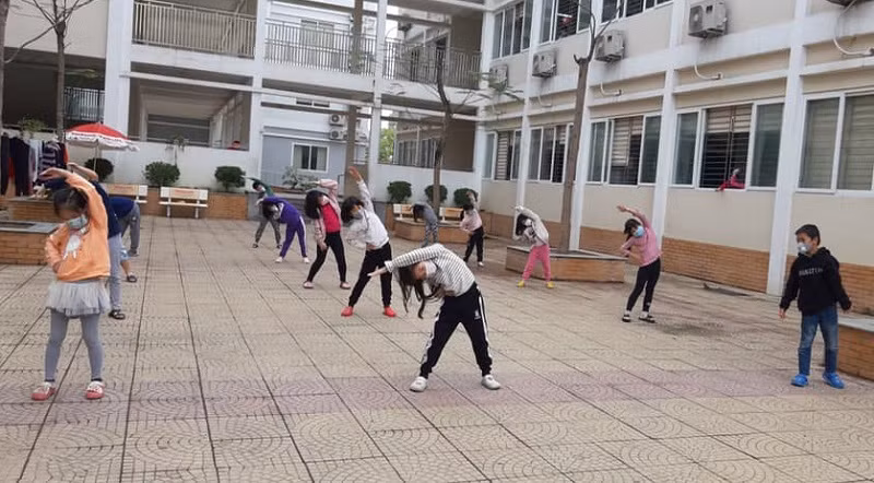 Học sinh tập thể dục trong khu cách ly Trường Tiểu học Xuân Phương.