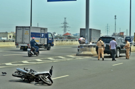 Tranh chai nuoc tren duong, nam thanh nien bi xe tai can ngang nguoi - Anh 1