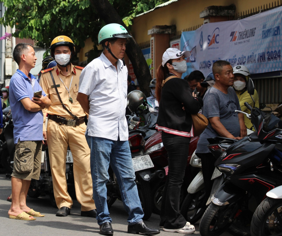 Tại điểm thi Trường THPT Nguyễn Chí Thanh, ngoài công tác phân luồng, chiến sĩ CSGT còn lắng nghe những tâm tư, tình cảm của phụ huynh trong lúc chờ thí sinh kết thúc giờ làm bài.